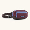 Patagonia 100% recycled nylon weather resistant terravia mini hip pack in maroon. Features 2 compartments with lilac zip detail