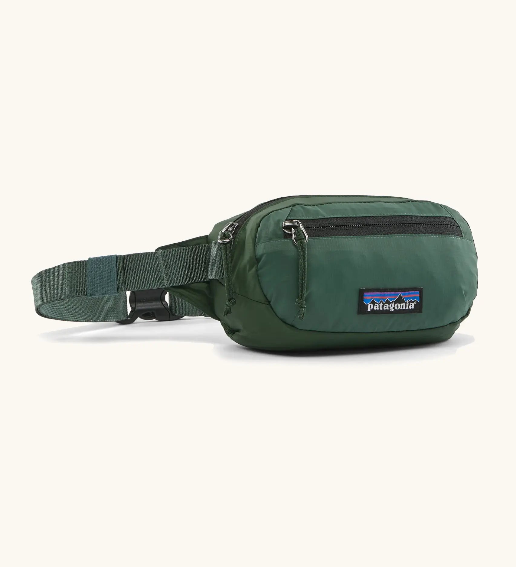 Patagonia 100% recycled nylon weather resistant terravia mini hip pack in dark green. Features 2 compartments with zipper fasteners