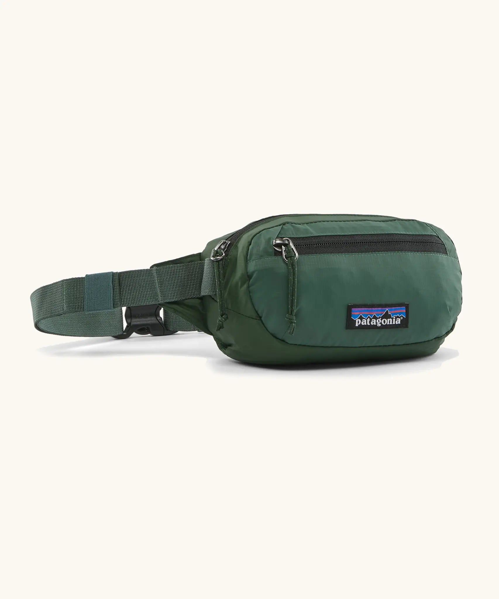 Patagonia 100% recycled nylon weather resistant terravia mini hip pack in dark green. Features 2 compartments with zipper fasteners