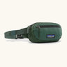 Patagonia 100% recycled nylon weather resistant terravia mini hip pack in dark green. Features 2 compartments with zipper fasteners