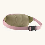 Patagonia Terravia Mini Bum Bag Hip pack in pale pink with green back panel showing quick release buckle on the strap