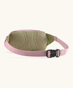 Patagonia Terravia Mini Bum Bag Hip pack in pale pink with green back panel showing quick release buckle on the strap