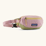 Patagonia recycled nylon terravia mini hip pack in pale pink with green bottom panel. Shows 2 zipped front pockets