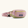 Patagonia recycled nylon terravia mini hip pack in pale pink with green bottom panel. Shows 2 zipped front pockets
