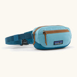 Patagonia 100% recycled nylon weather resistant terravia mini hip pack in bright blue. Features 2 compartments with orange zip detail