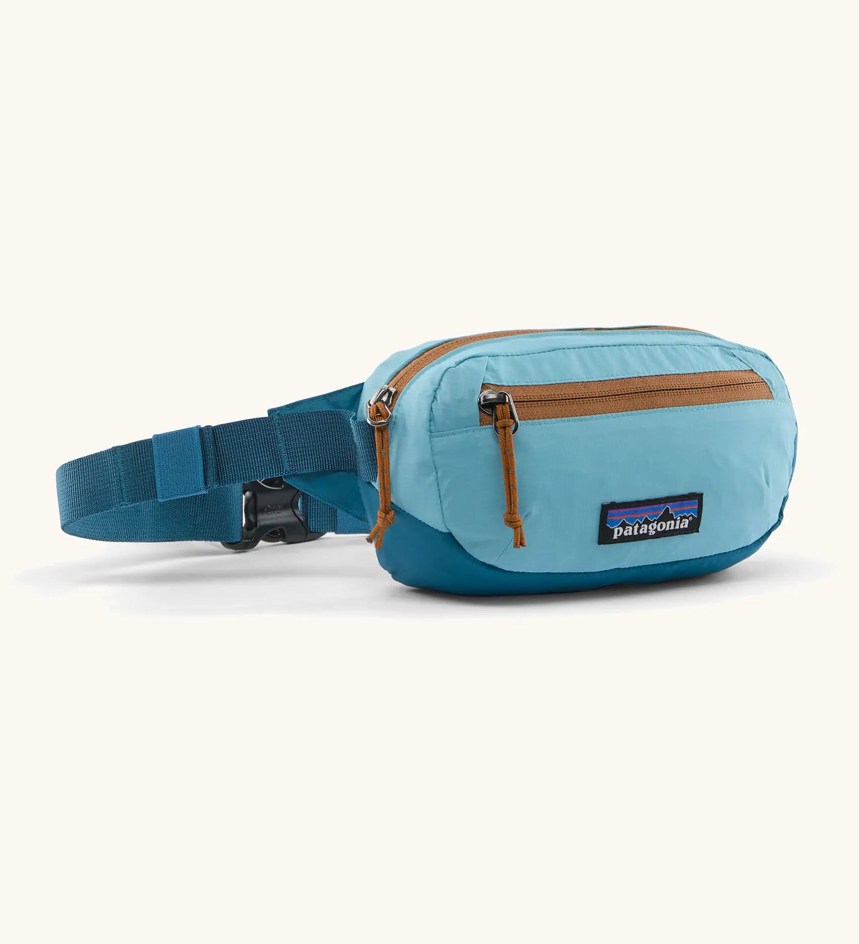Patagonia 100% recycled nylon weather resistant terravia mini hip pack in bright blue. Features 2 compartments with orange zip detail