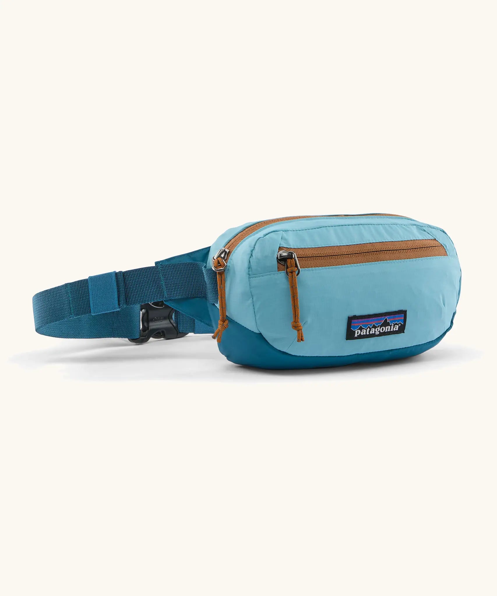 Patagonia 100% recycled nylon weather resistant terravia mini hip pack in bright blue. Features 2 compartments with orange zip detail