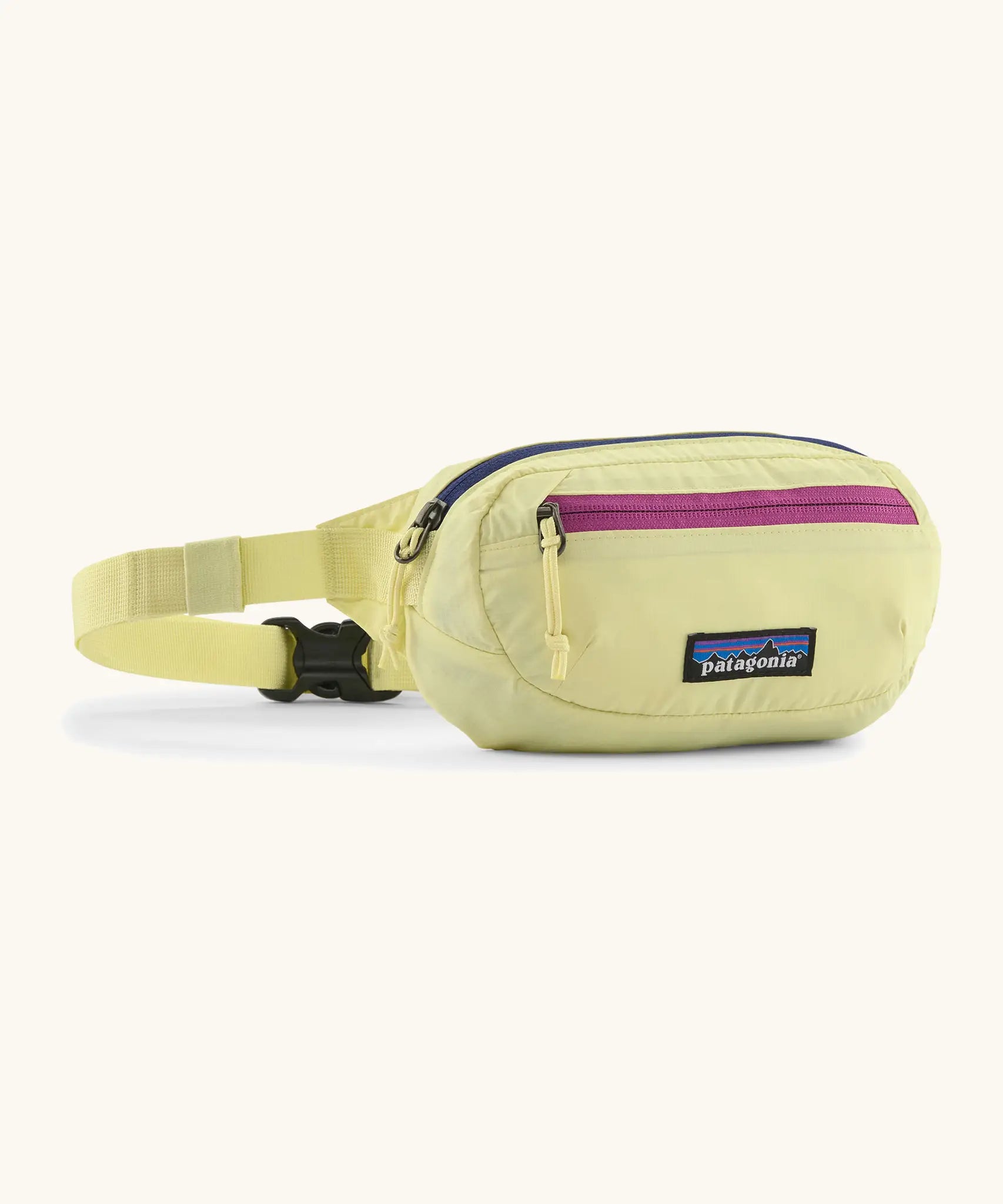 Patagonia 100% recycled nylon weather resistant terravia mini hip pack in pale yellow. Features 2 compartments with navy and pink zip detail