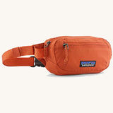 Patagonia terravia mini hip pack in orange made from recycled nylon and weather repellent. Shows 2 zipped front pockets