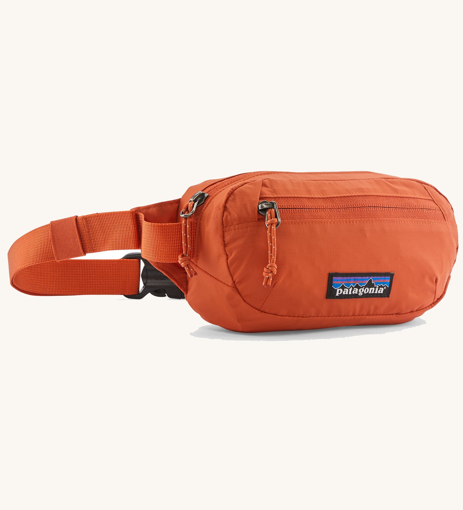 Patagonia terravia mini hip pack in orange made from recycled nylon and weather repellent. Shows 2 zipped front pockets