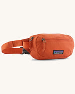 Patagonia terravia mini hip pack in orange made from recycled nylon and weather repellent. Shows 2 zipped front pockets