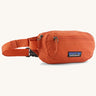 Patagonia terravia mini hip pack in orange made from recycled nylon and weather repellent. Shows 2 zipped front pockets