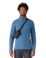 Man wearing Patagonia's terravia mini hip pack in black over the shoulder shows the front zipped pocket