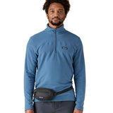 Man wearing Patagonia's terravia mini hip pack in black around the waist shows the front zipped pocket