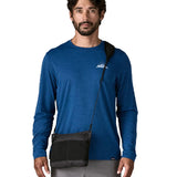 Man with a Patagonia lightweight terravia sacoche in black over the shoulder.