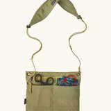 Patagonia quick-drying terravia sacoche in green showing small outdoor items inside drop in pockets