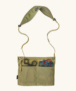 Patagonia quick-drying terravia sacoche in green showing small outdoor items inside drop in pockets