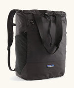 Patagonia water repellent Terravia tote bag in black. Features a front zip pocket, carry handle, side pockets and shoulder straps 