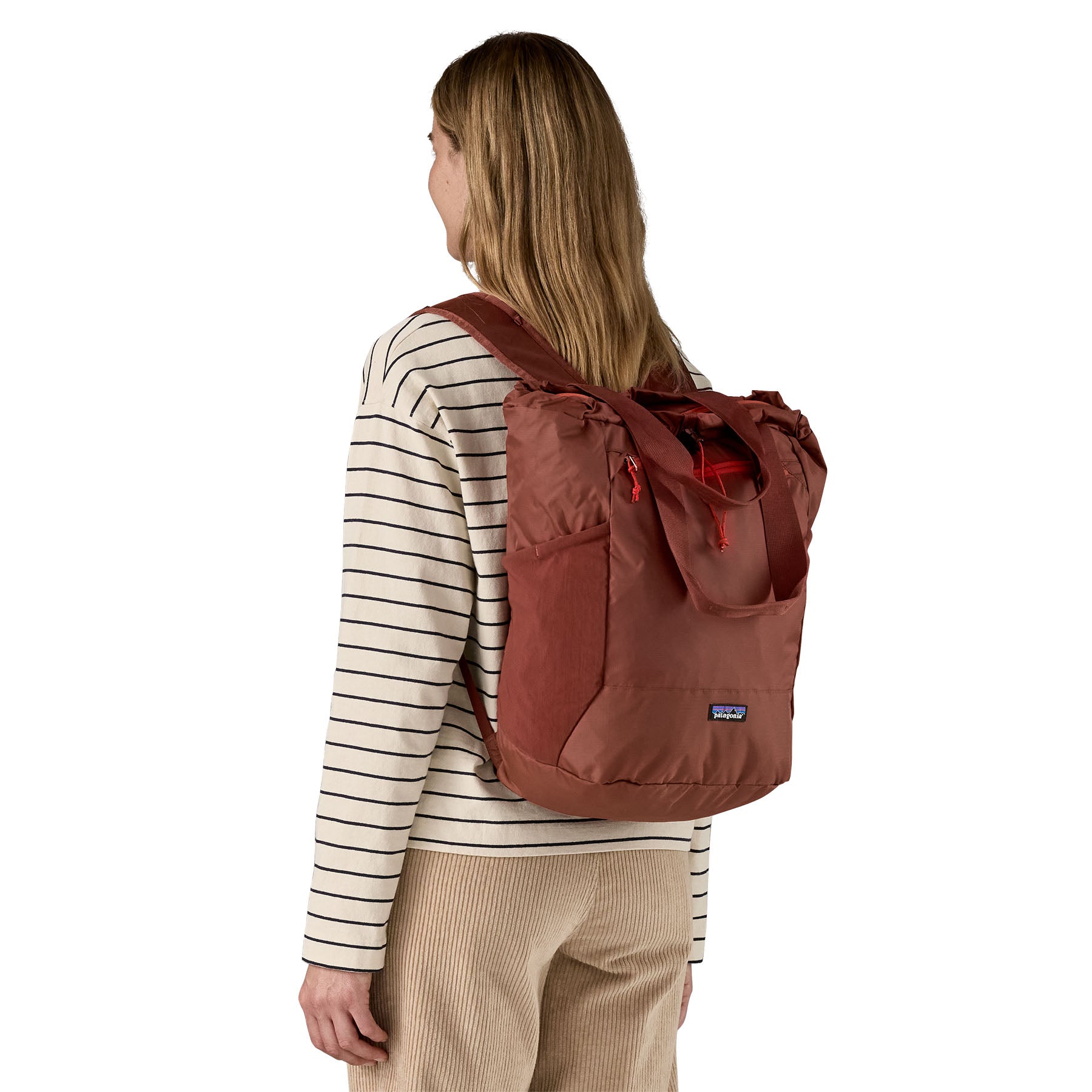 Patagonia Terravia tote bag in dried vanilla worn by a adult on the back available at Babipur showing the carrying handle details and side pockets for holding bottles