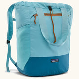Patagonia water repellent Terravia tote bag in bright blue with a darker blue bottom panel. Features a front zip pocket, carry handle, side pockets and shoulder straps 