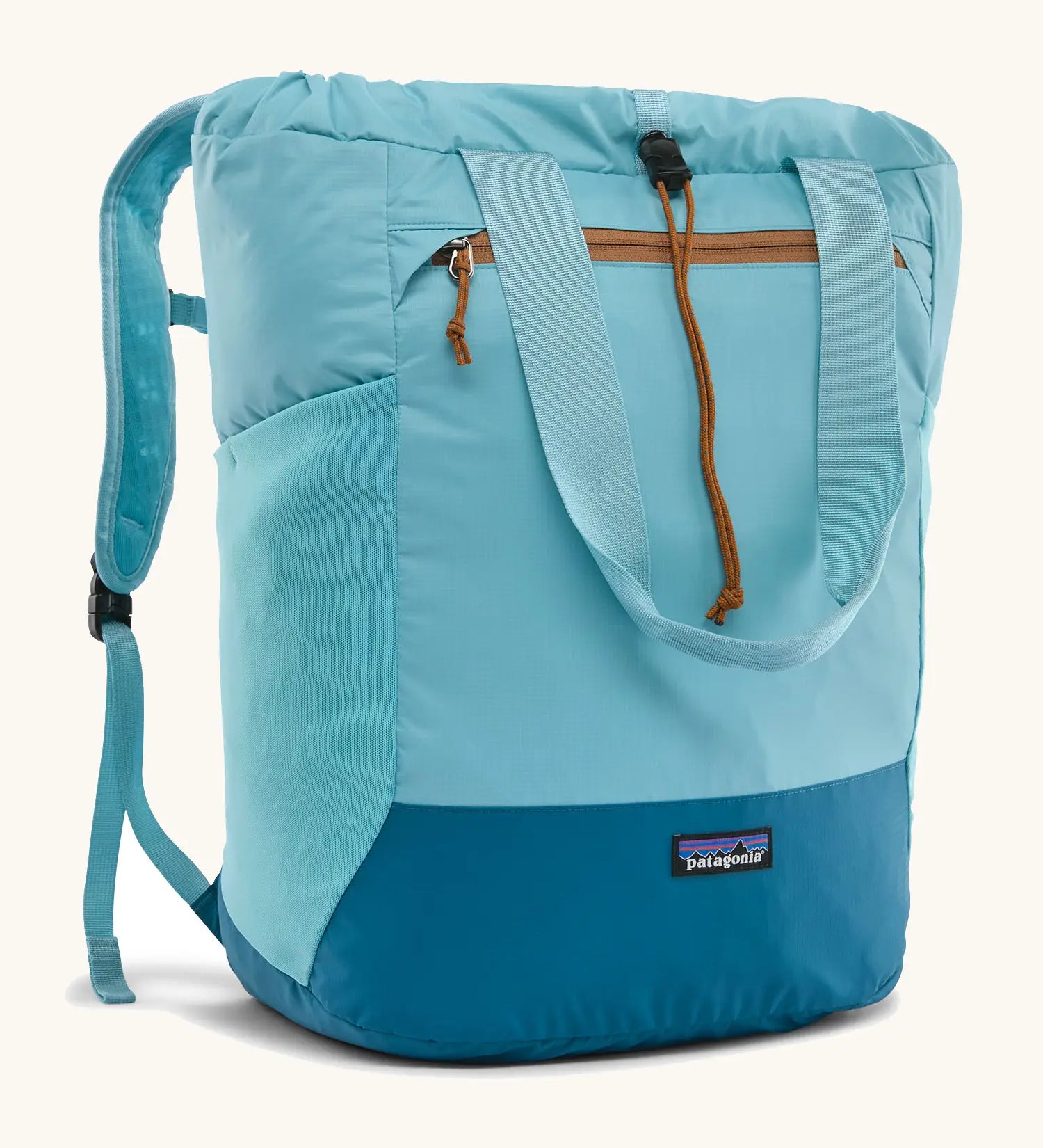 Patagonia water repellent Terravia tote bag in bright blue with a darker blue bottom panel. Features a front zip pocket, carry handle, side pockets and shoulder straps 