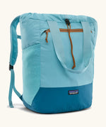 Patagonia water repellent Terravia tote bag in bright blue with a darker blue bottom panel. Features a front zip pocket, carry handle, side pockets and shoulder straps 