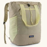Patagonia water repellent Terravia tote bag in beige with light yellow trim. Features a front zip pocket, carry handle, side pockets and shoulder straps 