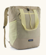 Patagonia water repellent Terravia tote bag in beige with light yellow trim. Features a front zip pocket, carry handle, side pockets and shoulder straps 