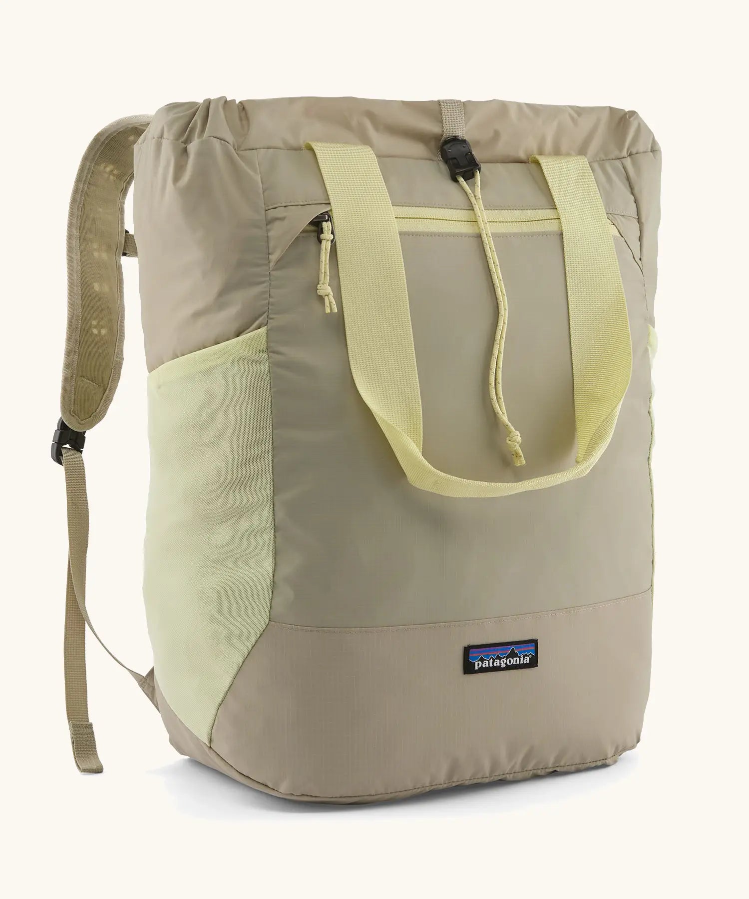Patagonia water repellent Terravia tote bag in beige with light yellow trim. Features a front zip pocket, carry handle, side pockets and shoulder straps 