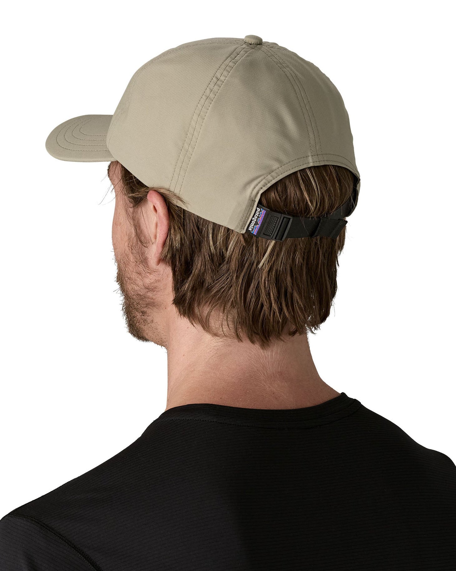 Man wearing Patagonia's recycled fast drying 100% nylon terrebonne cap in light green. Shows a adjustable strap on the back
