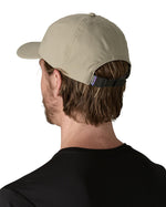 Man wearing Patagonia's recycled fast drying 100% nylon terrebonne cap in light green. Shows a adjustable strap on the back