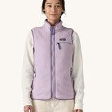A female standing in front of a cream background and wearing the light purple Patagonia women's thick fleece gilet with the zip fully closed