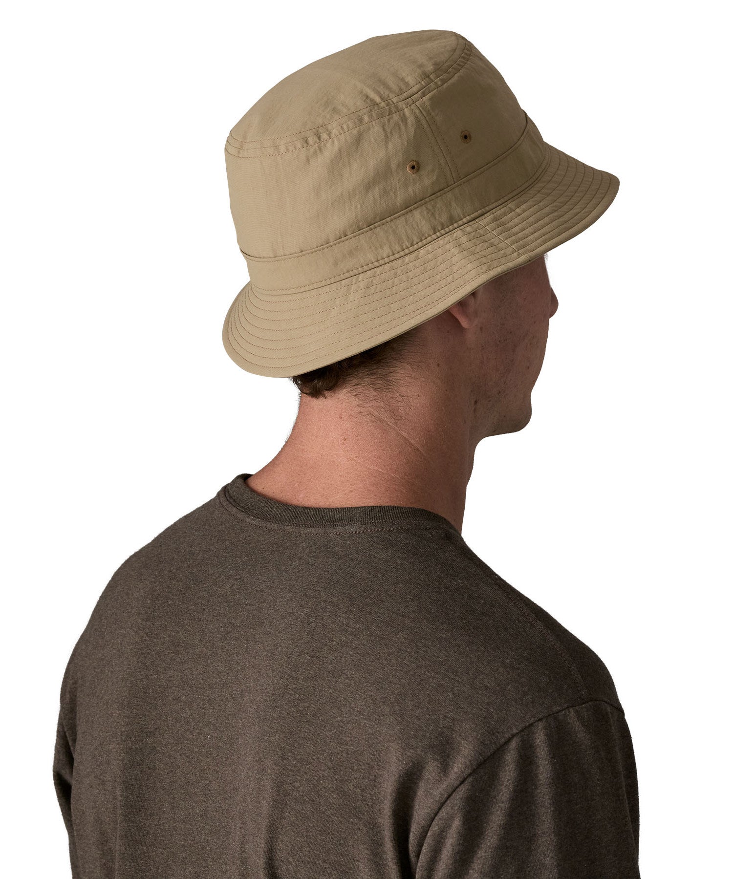 The back of man wearing Patagonia's 100% recycled nylon water repellent adult bucket hat in light brown. Shows 2 air holes on the side