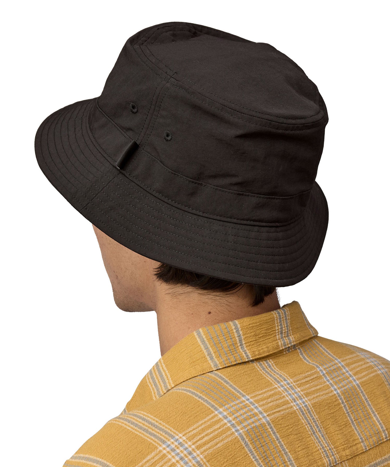 The back of man wearing Patagonia's 100% recycled nylon water repellent adult bucket hat in black. Shows 2 air holes on the side