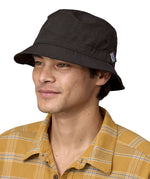 Man wearing Patagonia's 100% recycled nylon water repellent adult bucket hat in black. Shows 2 air holes on the side