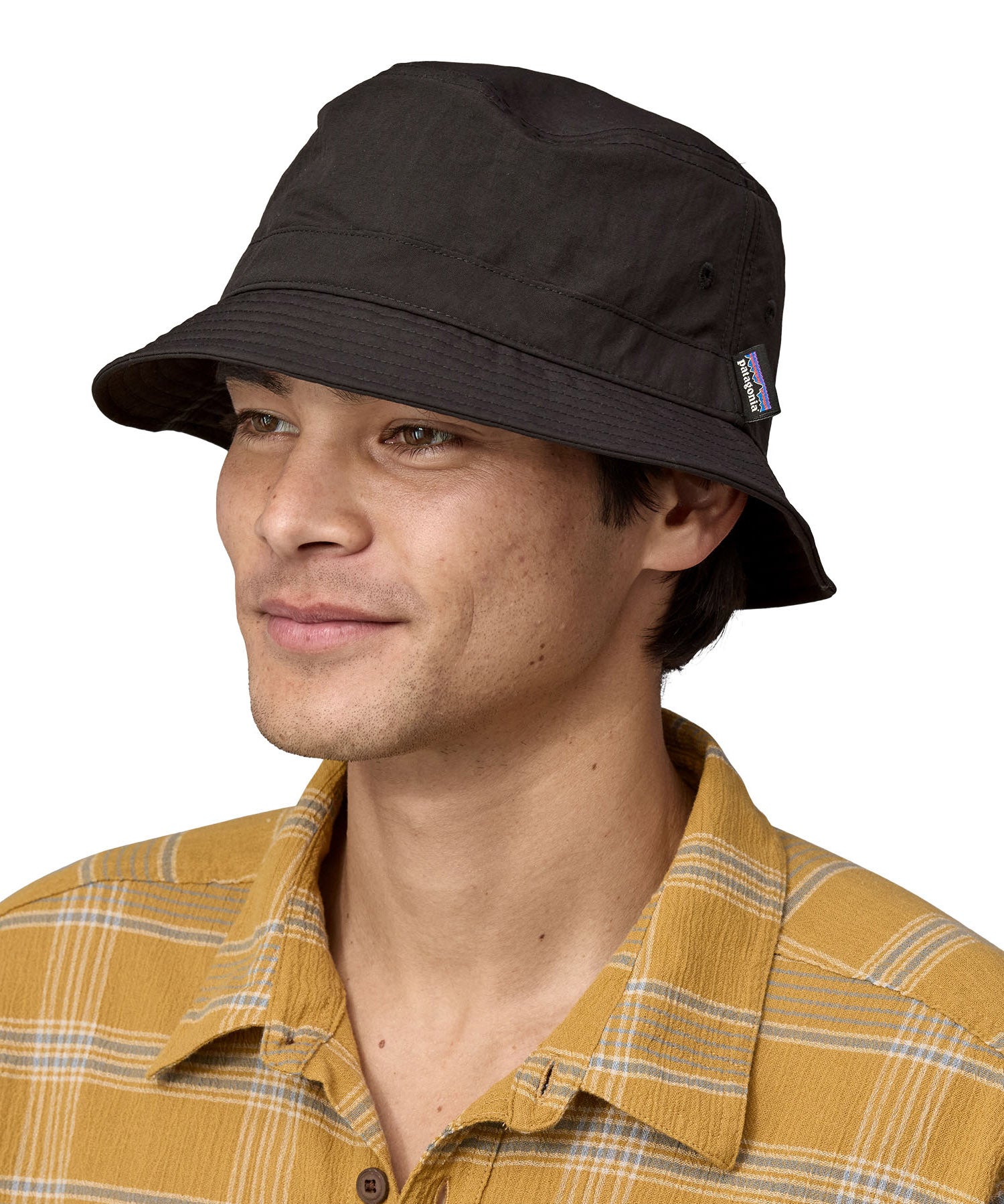 Man wearing Patagonia's 100% recycled nylon water repellent adult bucket hat in black. Shows 2 air holes on the side