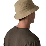 Back of man wearing Patagonia's breathable quick drying wavefarer bucket hat in khaki green with air holes on the side