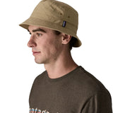 Side of man wearing Patagonia's breathable quick drying wavefarer bucket hat in khaki green 