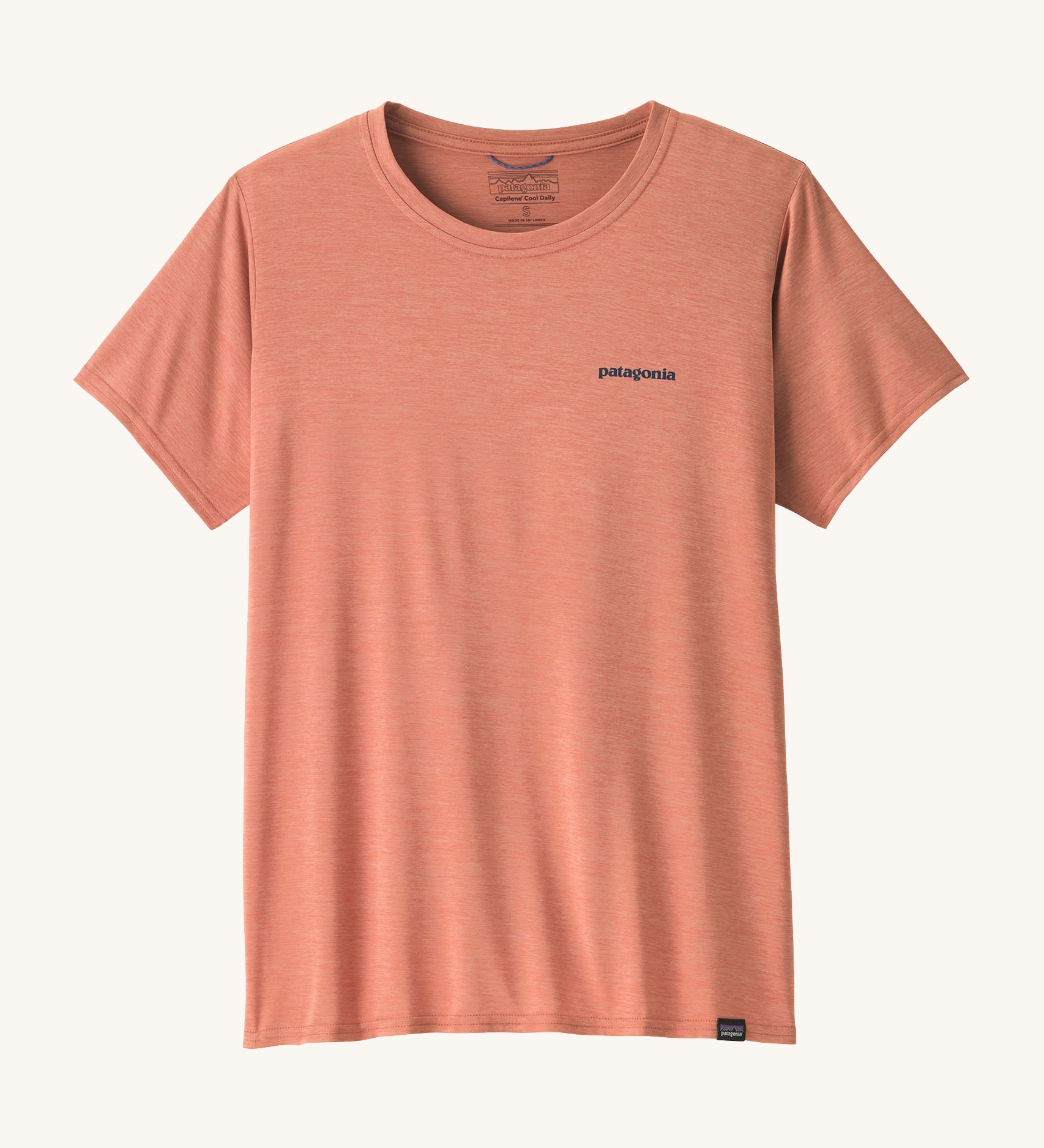 The front of the Patagonia Women's Capilene Cool Daily Graphic Shirt available at Babipur. A pastel pink coloured top with short sleeves and a brand name graphic on the chest