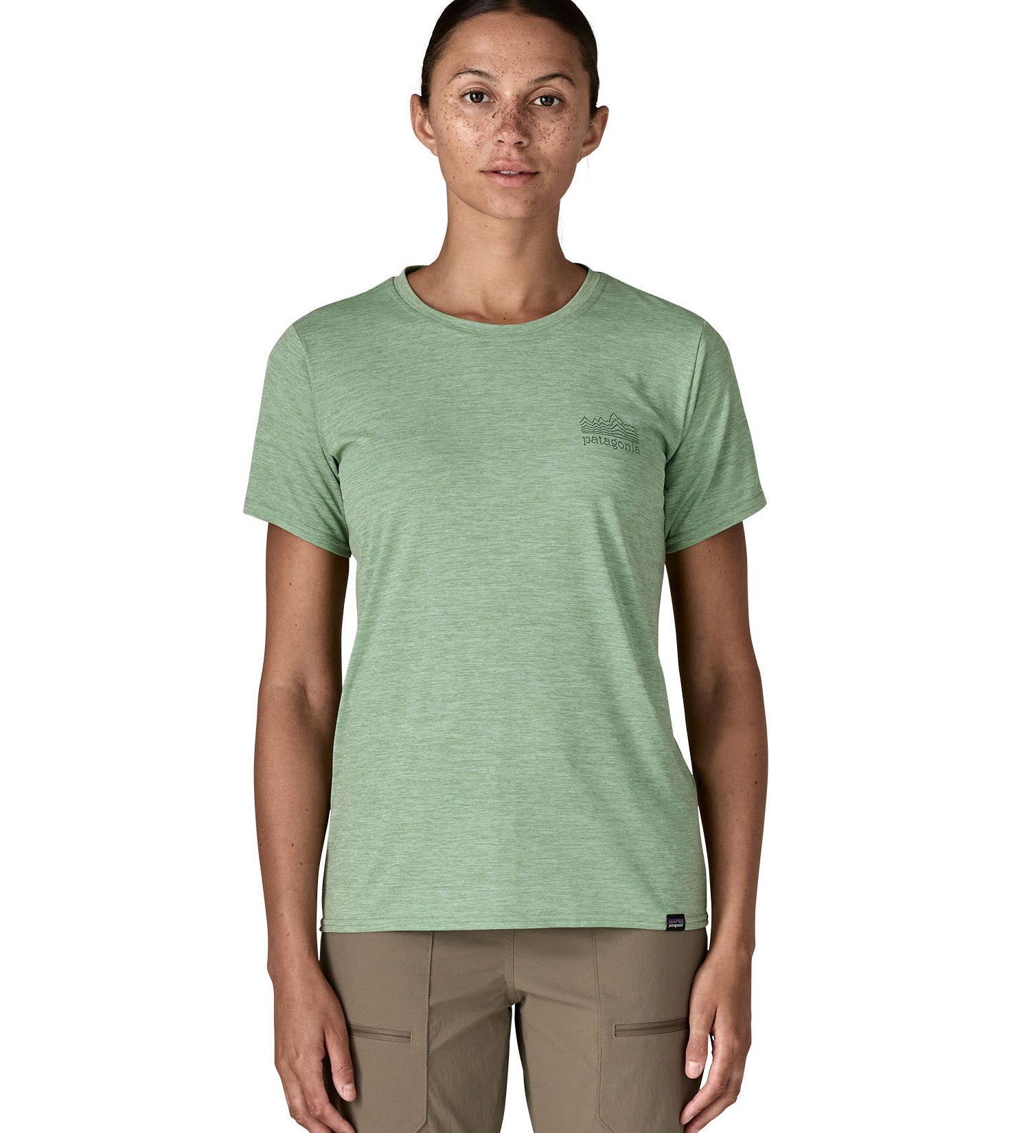 A woman wearing the Patagonia cool daily graphic short sleeve tshirt in ellwood  green with brand logo on the left chesr available at Babipur.
