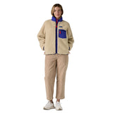 A woman wearing the Patagonia women's classic retro-x jacket in a dark natural colour way available at Babipur.