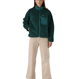 A woman wearing the Patagonia classic retro x women's jacket in cascade green available at Babipur. 