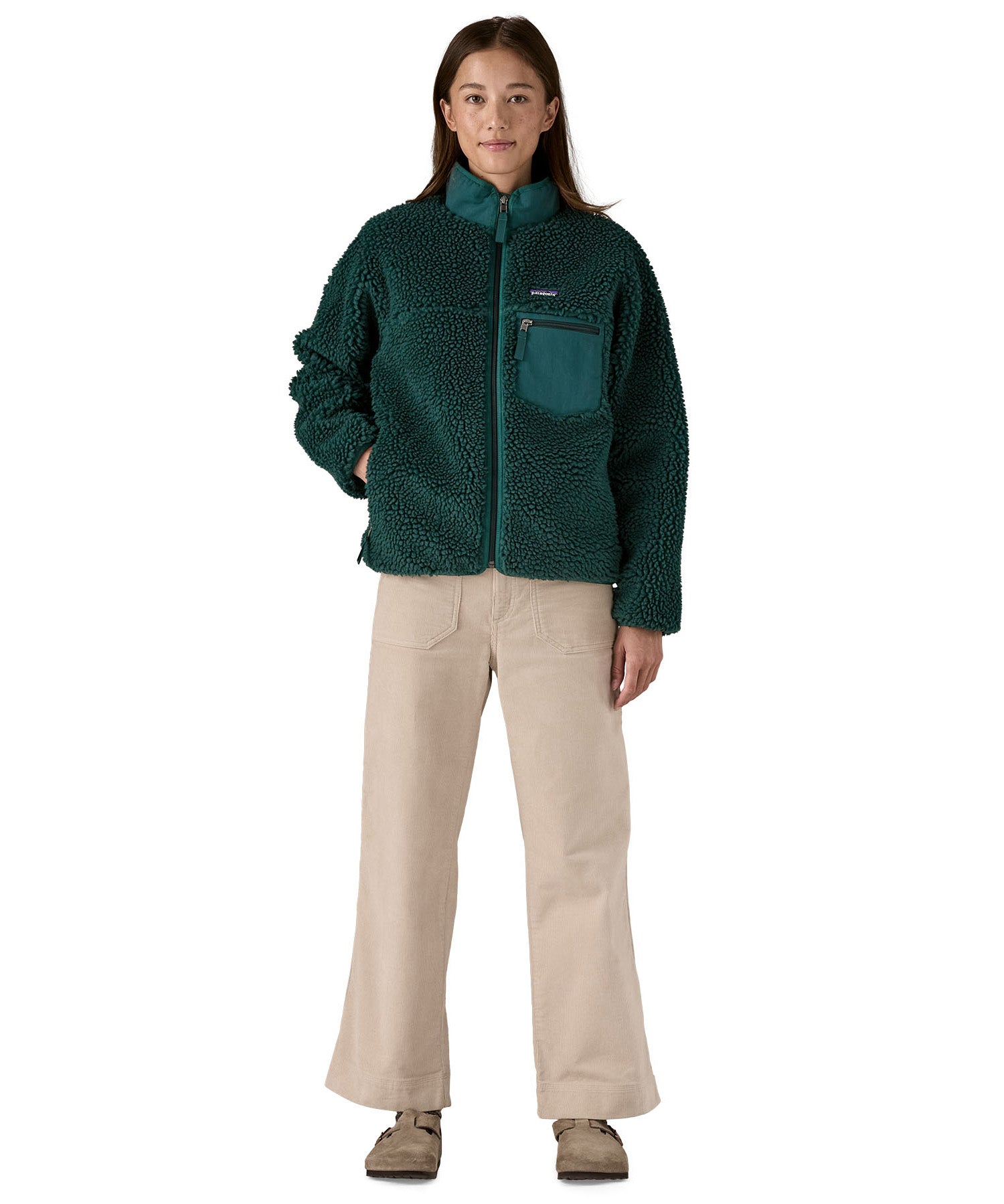 A woman wearing the Patagonia classic retro x women's jacket in cascade green available at Babipur. 