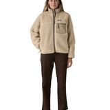 A woman wearing the Patagonia classic retro x women's jacket in natural available at Babipur. 