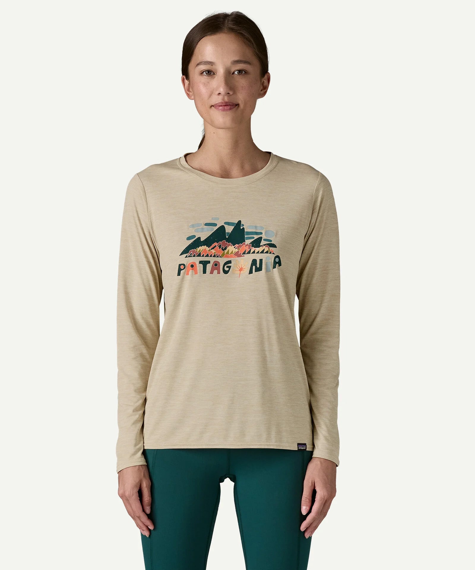 Woman wearing the Patagonia Women’s Long Sleeved Capilene Cool Daily Graphic Shirt in Fitz Roy Foliage, featuring the mountain graphic and Patagonia logo on the chest.