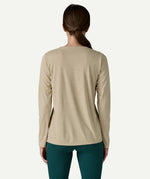 Back view of a woman wearing the Patagonia Women’s Long Sleeved Capilene Cool Daily Graphic Shirt in Fitz Roy Foliage, showcasing the long sleeved technical fabric.