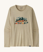 Front view of the Patagonia Women’s Long Sleeved Capilene Cool Daily Graphic Shirt in Fitz Roy Foliage Pumice X-Dye, showing the mountain scene graphic and Patagonia logo on the chest.