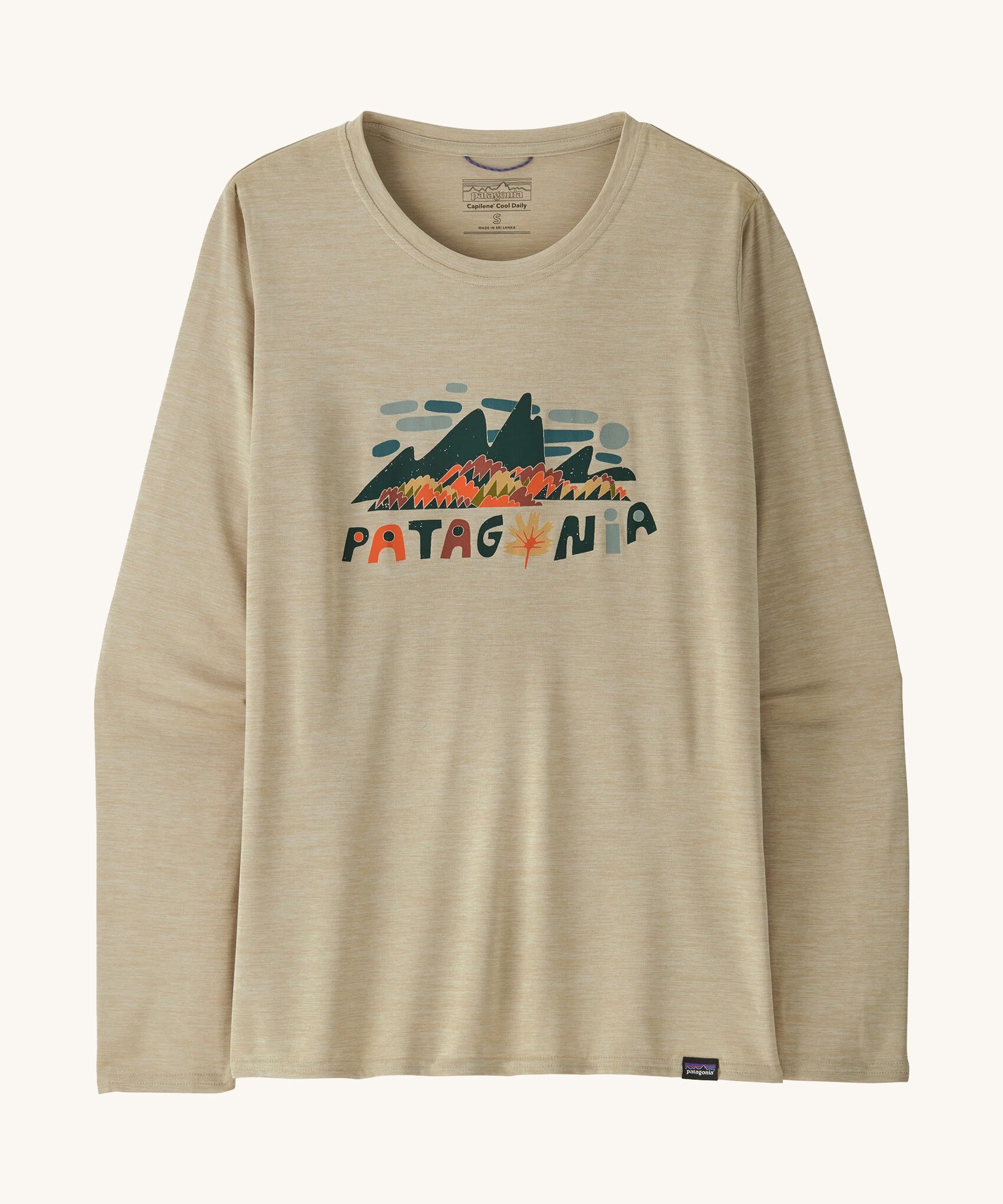 Front view of the Patagonia Women’s Long Sleeved Capilene Cool Daily Graphic Shirt in Fitz Roy Foliage Pumice X-Dye, showing the mountain scene graphic and Patagonia logo on the chest.