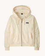 Patagonia women's Anhya hoody in cream. Shows a full length front zip and pouch pockets 