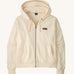 Patagonia women's Anhya hoody in cream. Shows a full length front zip and pouch pockets 